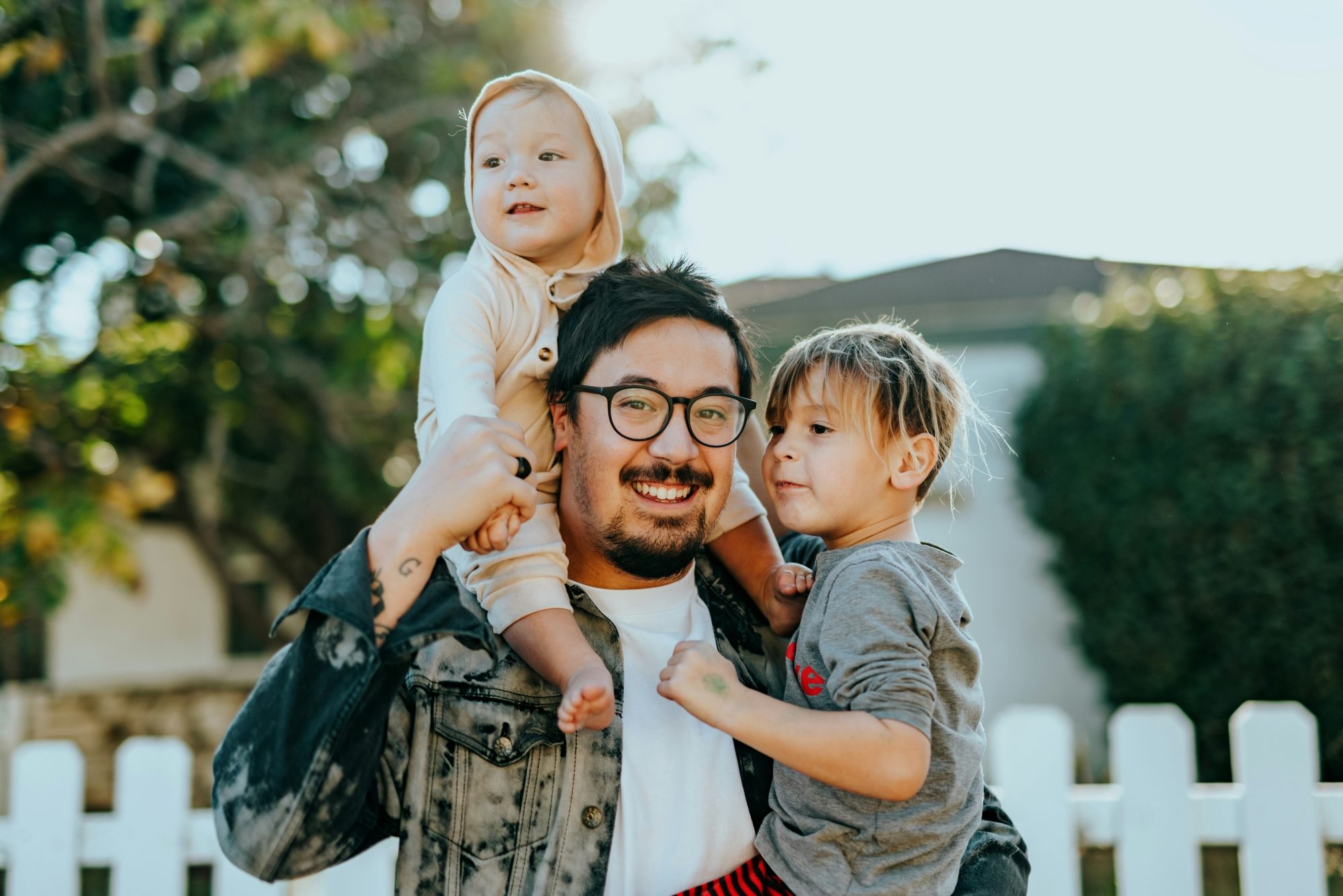 Un père porte ses deux enfants dans les bras
