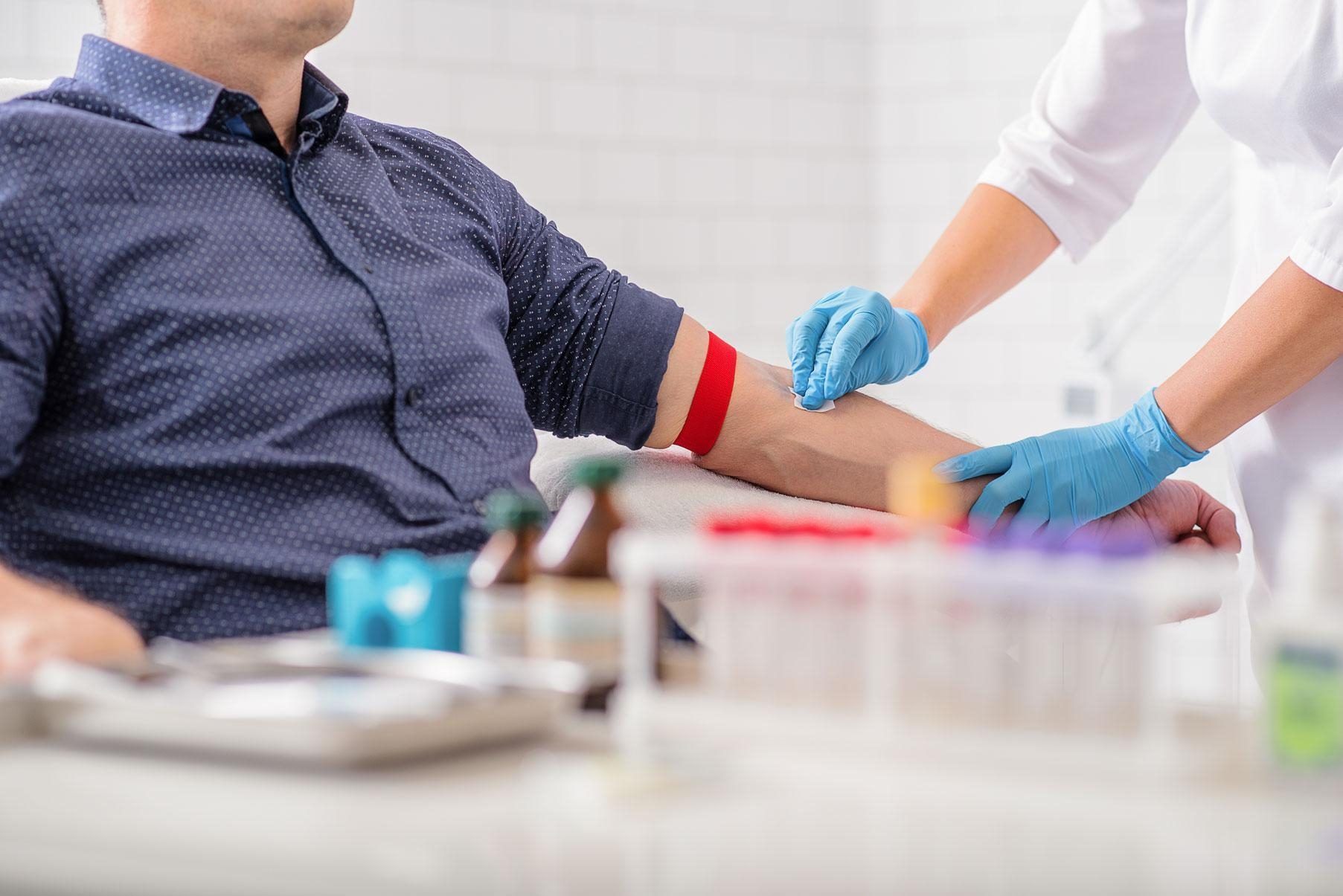 Une infirmière prépare le bras d'un homme pour une injection