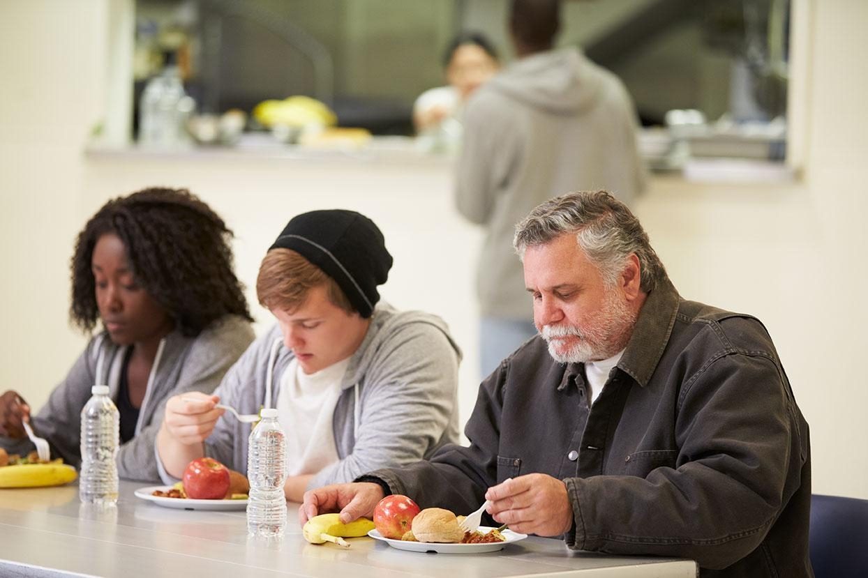 Trois personnes sont attablées devant un repas chaud