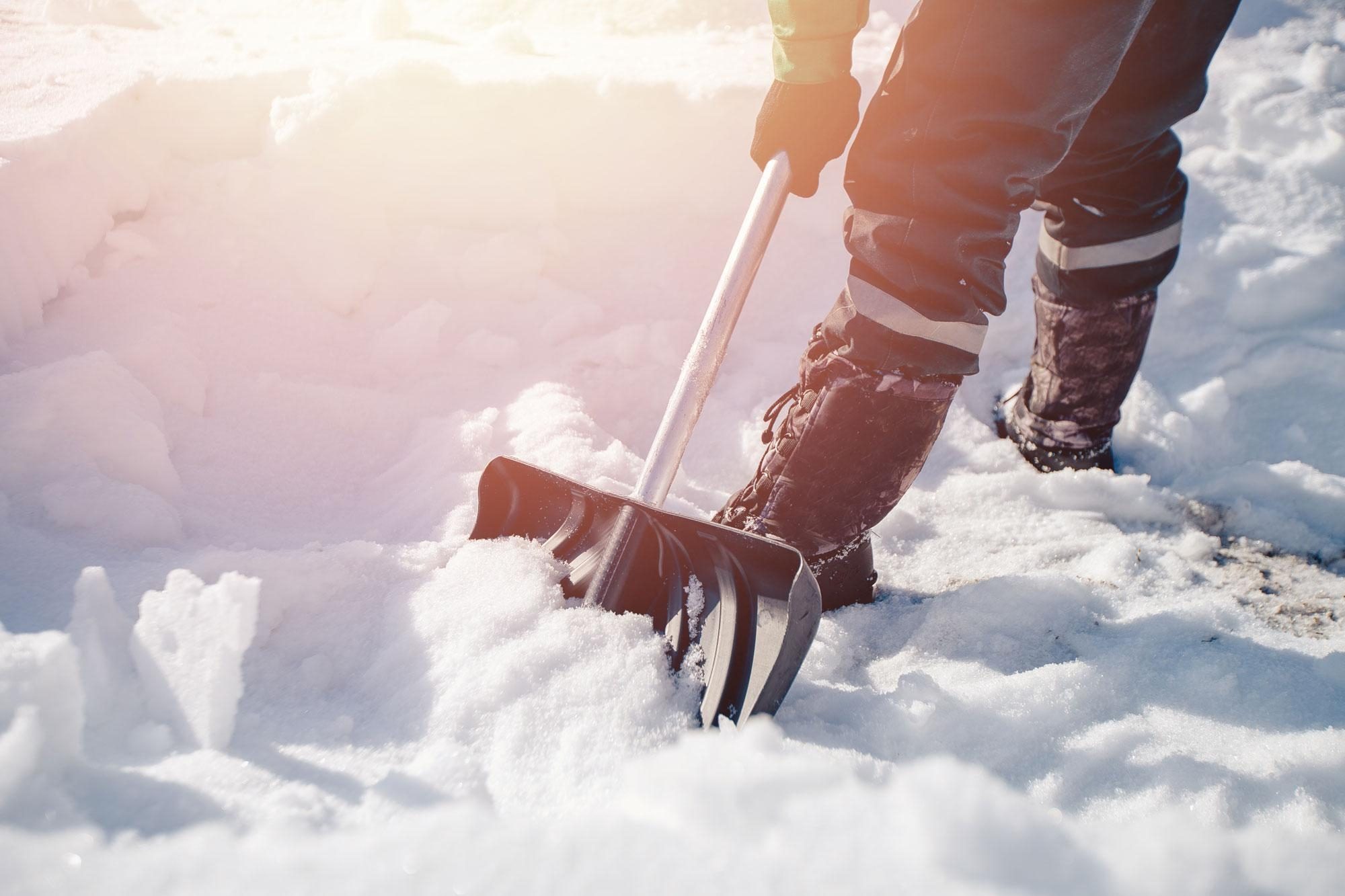 Une personne déneige avec une pelle